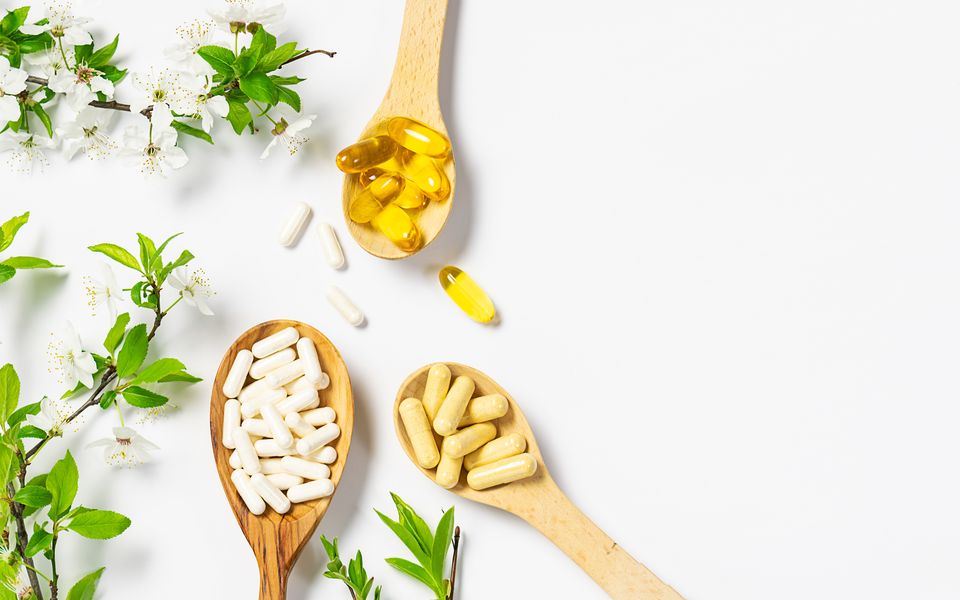 Supplement capsules on wooden spoons
